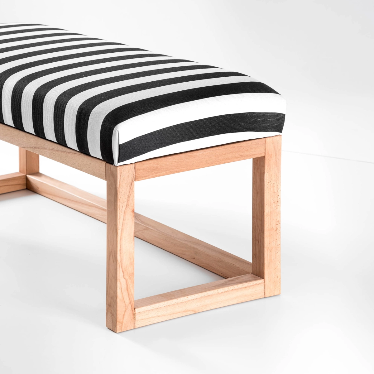 Moderne bank met gestreepte bekleding, plank en houten frame
