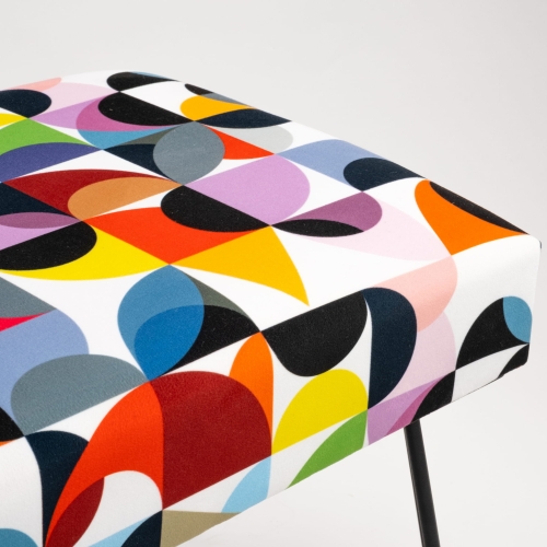 Gestoffeerde bank met kleurrijke patronen en pinpoten