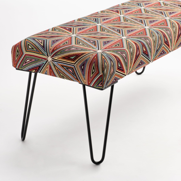 Gestoffeerde bank met patroon op metalen poten, ideaal voor industriële interieurs