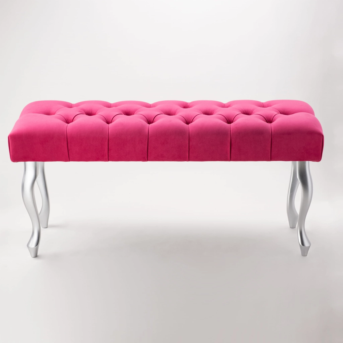 Elegante gewatteerde bank in intense fuchsia kleur met zilveren poten