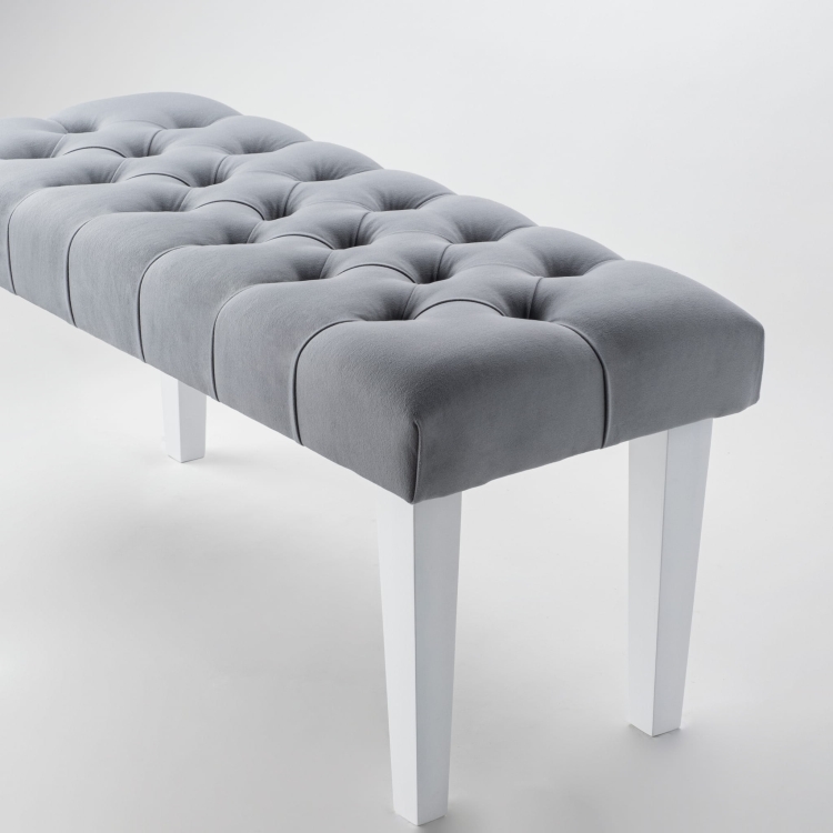Stijlvolle bank in grijs met gewatteerde bekleding en witte poten