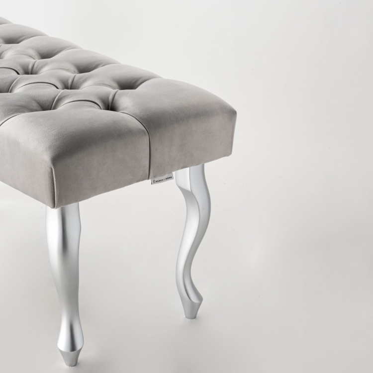 Grijs gestoffeerde bank op zilverkleurige metalen poten