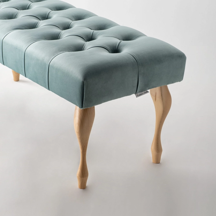 Gewatteerde bank in mintkleur met klassieke houten poten